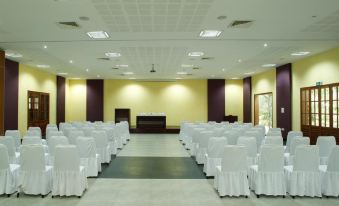 a large conference room with rows of white chairs arranged in a semicircle , ready for a meeting or presentation at Poovar Island Resort