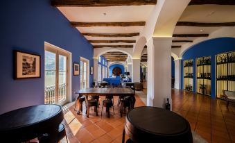 a large room with blue walls and white ceiling , featuring multiple tables and chairs arranged around them at The Vintage House - Douro