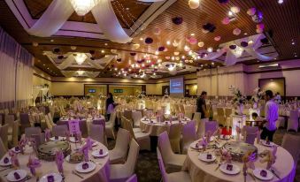 a large banquet hall filled with tables and chairs , all set up for a formal event at Palm Beach Resort & Spa