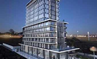 a modern building with multiple floors , situated on a hillside with a view of the city at Golden Tulip Istanbul Bayrampasa