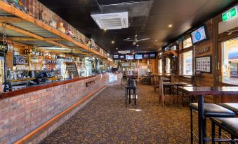 a restaurant with a bar area , where several people are seated and enjoying their meals at Prince of Wales Hotel Gulgong