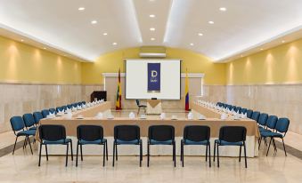 a conference room set up for a meeting , with chairs arranged in rows and a projector screen mounted on the wall at Hotel Dann Cartagena