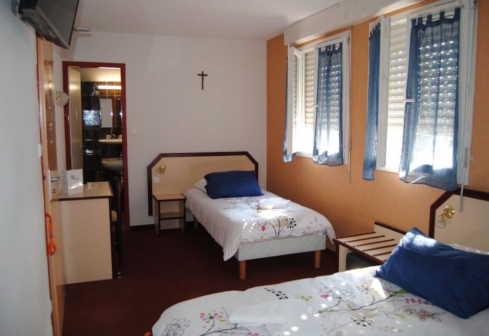 a hotel room with two beds , one on the left and one on the right side of the room at Myosotis
