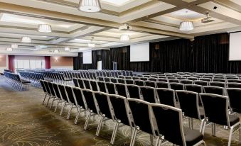 a large conference room with rows of chairs arranged in a semicircle , ready for an event at Mercure Gold Coast Resort