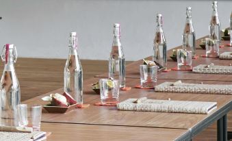 a table is set with various items , including wine glasses and bottles , on wooden surfaces at Six Senses YAO Noi