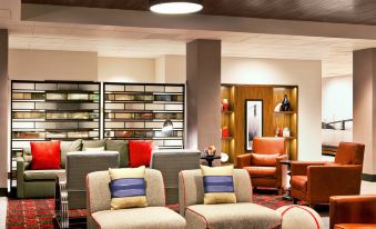 a modern living room with comfortable furniture , including couches , chairs , and a dining table at Four Points by Sheraton - San Francisco Bay Bridge