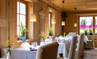 a restaurant with wooden walls and ceiling , tables set for dining , and hanging lights at Adler Spa Resort Dolomiti