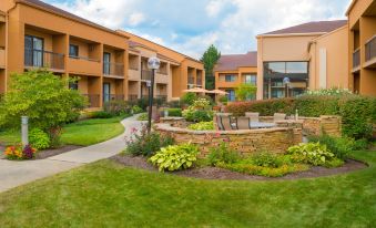 a courtyard surrounded by a brick building , with several chairs and tables set up for outdoor dining at Courtyard Chicago Deerfield