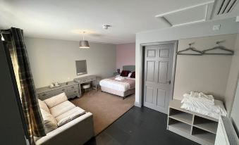 a modern hotel room with a white bed , desk , and couch , along with a desk and chair at The Black Horse Inn