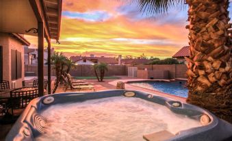 a beautiful sunset view from a patio with a hot tub and pool , creating a serene atmosphere at Arrowhead