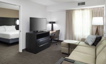 a living room with a couch , television , and a chair in front of a desk at Residence Inn Boston Westford