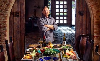 a man standing in front of a dining table filled with a variety of dishes and wine glasses at Tubac Golf Resort & Spa