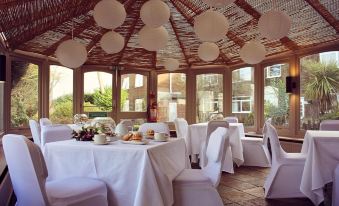 a dining room with tables and chairs arranged for a group of people to enjoy a meal together at Birch Hotel