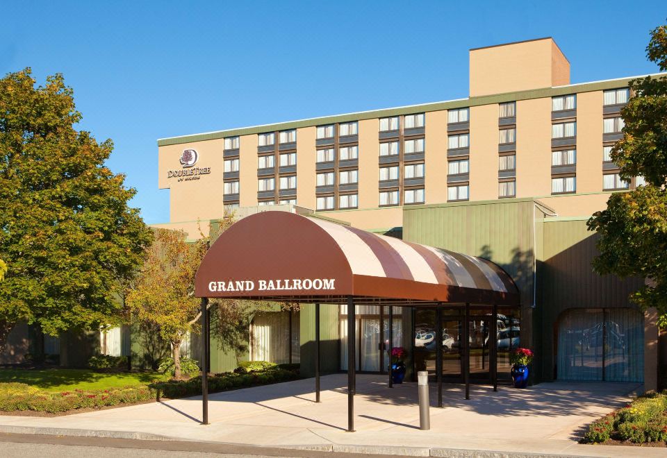 a large building with a grand ballroom sign on the front , surrounded by trees and other buildings at DoubleTree Boston North Shore Danvers