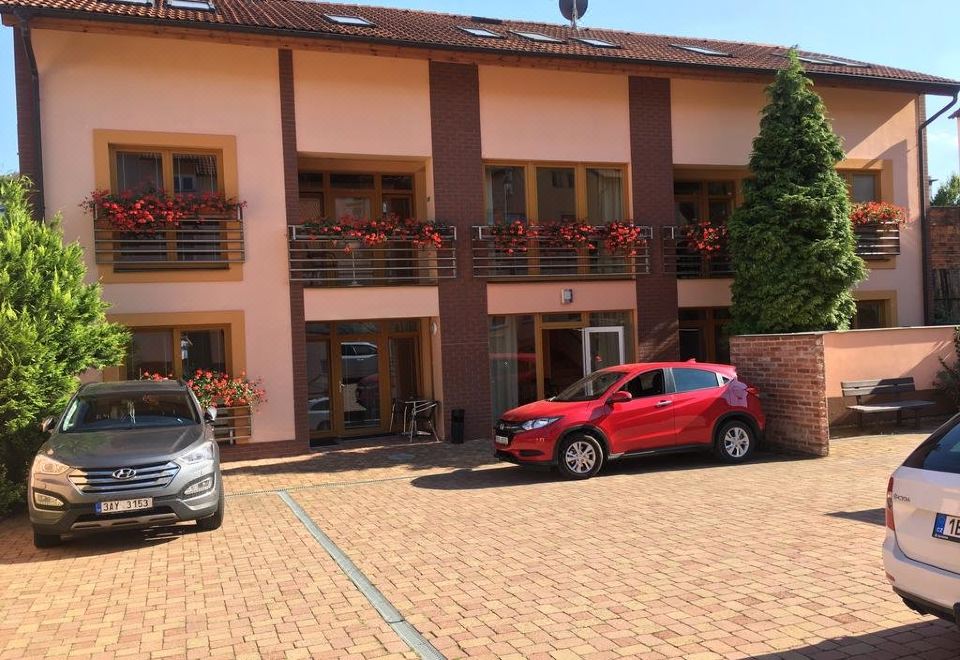 a red car is parked in front of a building with balconies decorated for the holidays at Hotel City