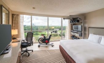 a modern bedroom with a large window overlooking the city , and a stationary bike in the room at Hilton Memphis
