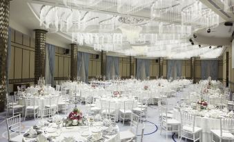 a large , empty banquet hall with white chairs and tables set up for a formal event at Divan Mersin