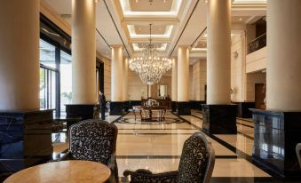 a luxurious hotel lobby with marble floors , high ceilings , and a large chandelier hanging from the ceiling at DiplomaticHotel
