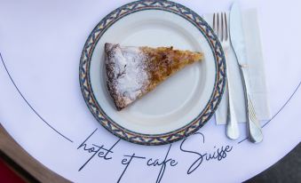 "a slice of cake is placed on a plate with the words "" hotel de café suisse "" written below it" at Hotel Suisse