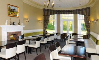 a large dining room with numerous tables and chairs arranged for a group of people at Hundith Hill Hotel