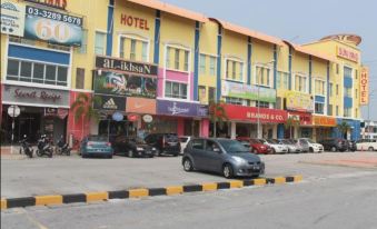 a city street with multiple buildings , including a hotel and a restaurant , along with parked cars at Sun Inns Hotel Kuala Selangor