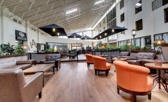 a large , open room with wooden floors and walls , featuring several chairs and tables arranged in an open space at The Atrium Hotel on Third