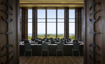 a large conference room with rows of chairs arranged in front of a large window overlooking a field at Nizuc Resort & Spa