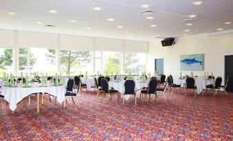 a large dining room with multiple tables and chairs set up for a formal event at Hotel Marina