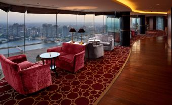 a luxurious hotel room with a large window overlooking the city , providing a beautiful view of the skyline at Grand Nile Tower