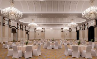 a large , elegant banquet hall with multiple tables and chairs set up for a formal event at The Ritz-Carlton, Doha