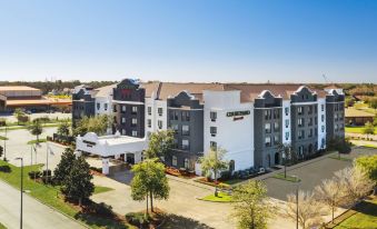 "a large , white - themed hotel building with the name "" courtyard marriott "" on it , surrounded by green trees and clear blue skies" at Courtyard Houma