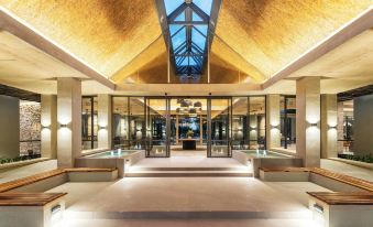 a modern building with an open atrium , glass doors , and wooden beams , giving it an inviting atmosphere at Mokuti Etosha