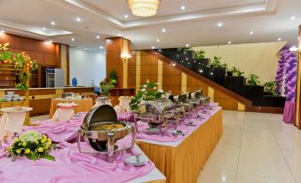 a large dining room with a long buffet table filled with various dishes and utensils at Muong Thanh Dien Chau Hotel