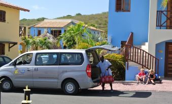 a group of people standing next to a van parked on the side of the road at Kunuku Resort All Inclusive Curacao, Trademark by Wyndham