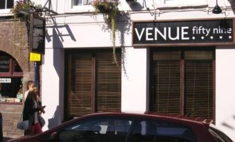 "a white building with a sign that reads "" venue fifth "" prominently displayed on the front of the building" at The Kings Head Hotel