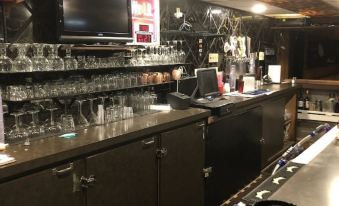 a bar with a long counter , multiple televisions on the wall , and various glasses and bottles on display at Challis Roadhouse