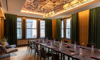 a conference room with a long table and chairs , surrounded by windows and decorated ceiling at Canopy by Hilton Philadelphia Center City