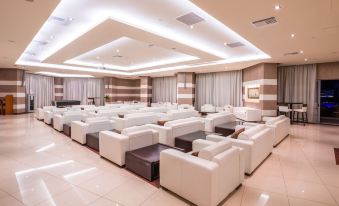 a large room with multiple white couches arranged in rows , creating a comfortable seating area at Konstantinos Palace