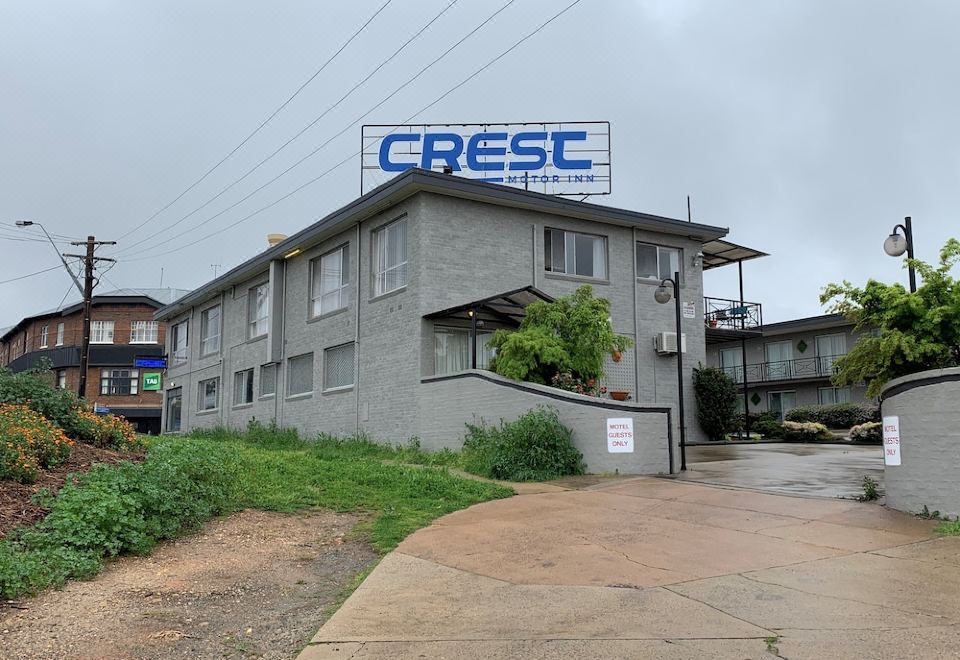 "a large building with a sign that says "" crese "" on the side , located in a residential area" at Crest Motor Inn