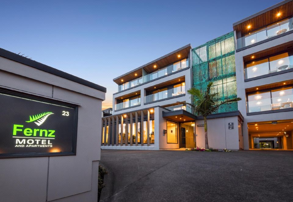 "a large building with a green awning and a sign that says "" redcliffe 2 2 ""." at Fernz Motel & Apartments Birkenhead