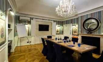 a conference room with a long wooden table , chairs , and a chandelier hanging from the ceiling at Harbour Hotel & Spa Christchurch