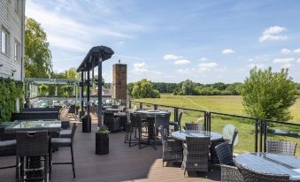 a rooftop patio with a variety of chairs and tables , creating a pleasant outdoor dining experience at The Mill Hotel