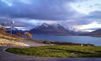a scenic view of a lake with mountains in the background and a road on the right side at Isle of Raasay Distillery