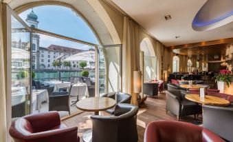 a modern lounge area with large windows and curved sofas , creating a comfortable and inviting atmosphere at Hotel des Balances