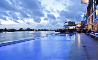 a large outdoor swimming pool surrounded by chairs and benches , with a view of the water and sky at Radisson Blu Anchorage Hotel