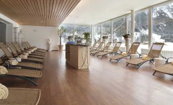 a large room with wooden floors and chairs arranged in rows , possibly for a massage or other therapy at Sunstar Hotel & Spa Grindelwald