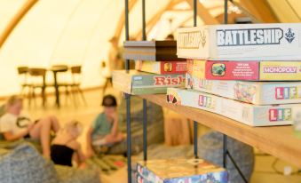 a group of children playing a board game on a shelf in a room filled with bean bags at Under Canvas Mount Rushmore