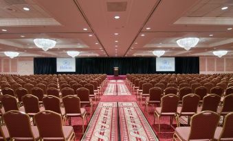 a large conference room with rows of chairs arranged in a semicircle , ready for an event at Hilton St. Louis Frontenac