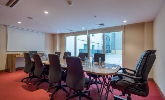 a conference room with several chairs arranged in a semicircle around a table , and a window overlooking the city at Hampton by Hilton Kahramanmaras