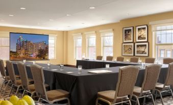a conference room set up for a meeting , with chairs arranged in a semicircle around a table at The Moonrise Hotel
